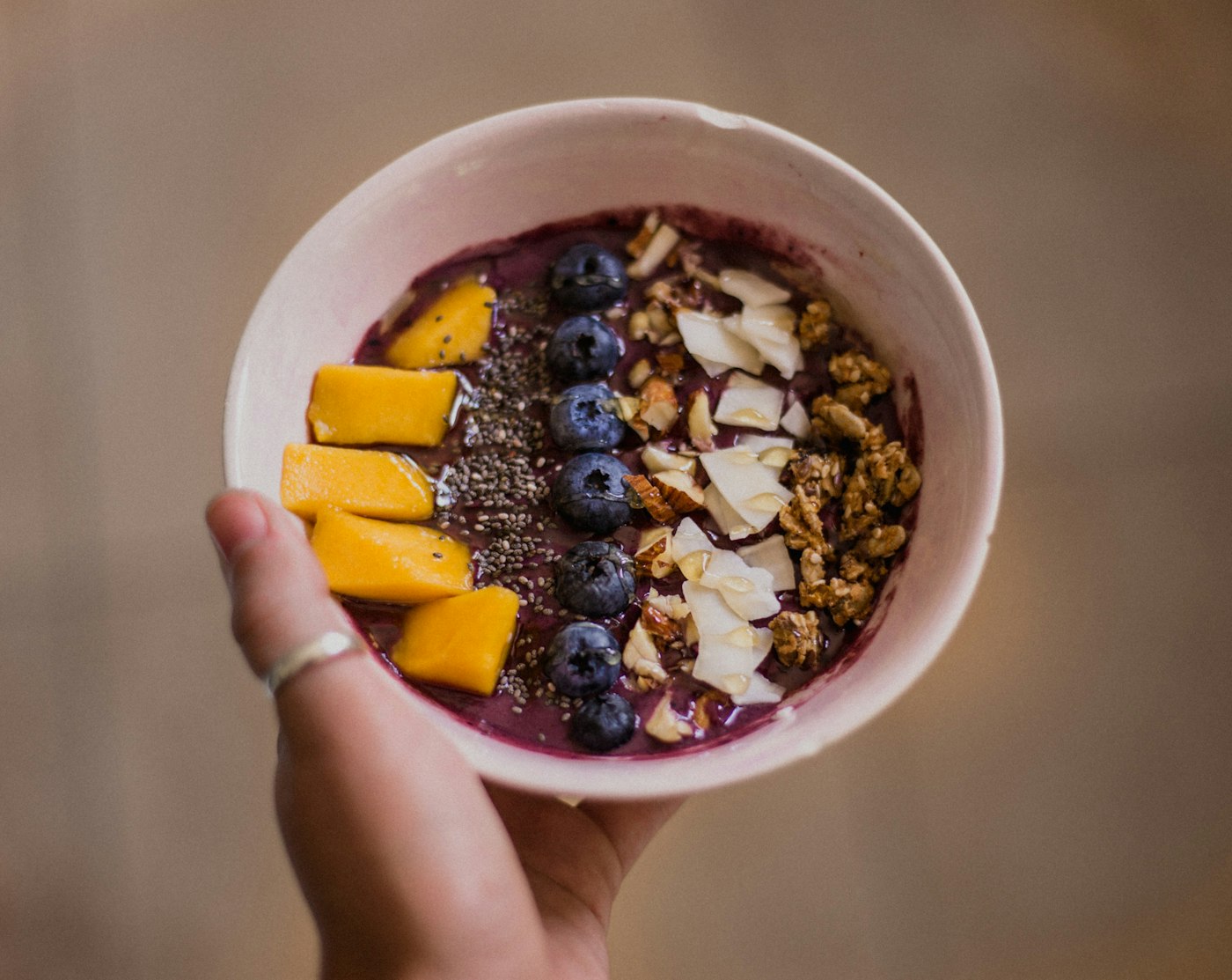 Tigela de a&ccedil;a&iacute; servida na m&atilde;o do cliente