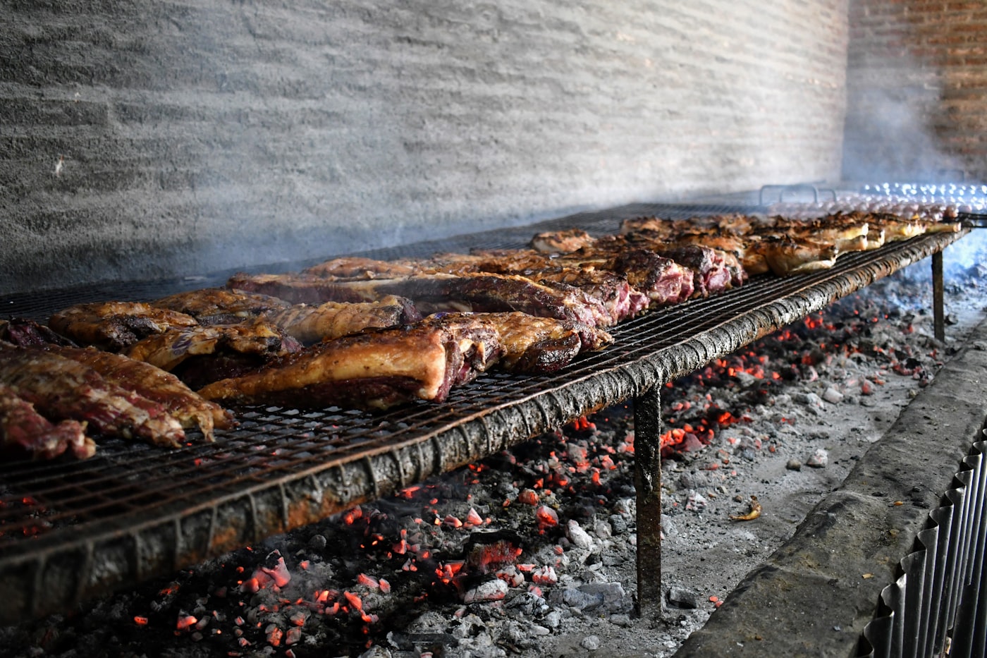 Fileira de espetos assando sobre a brasa
